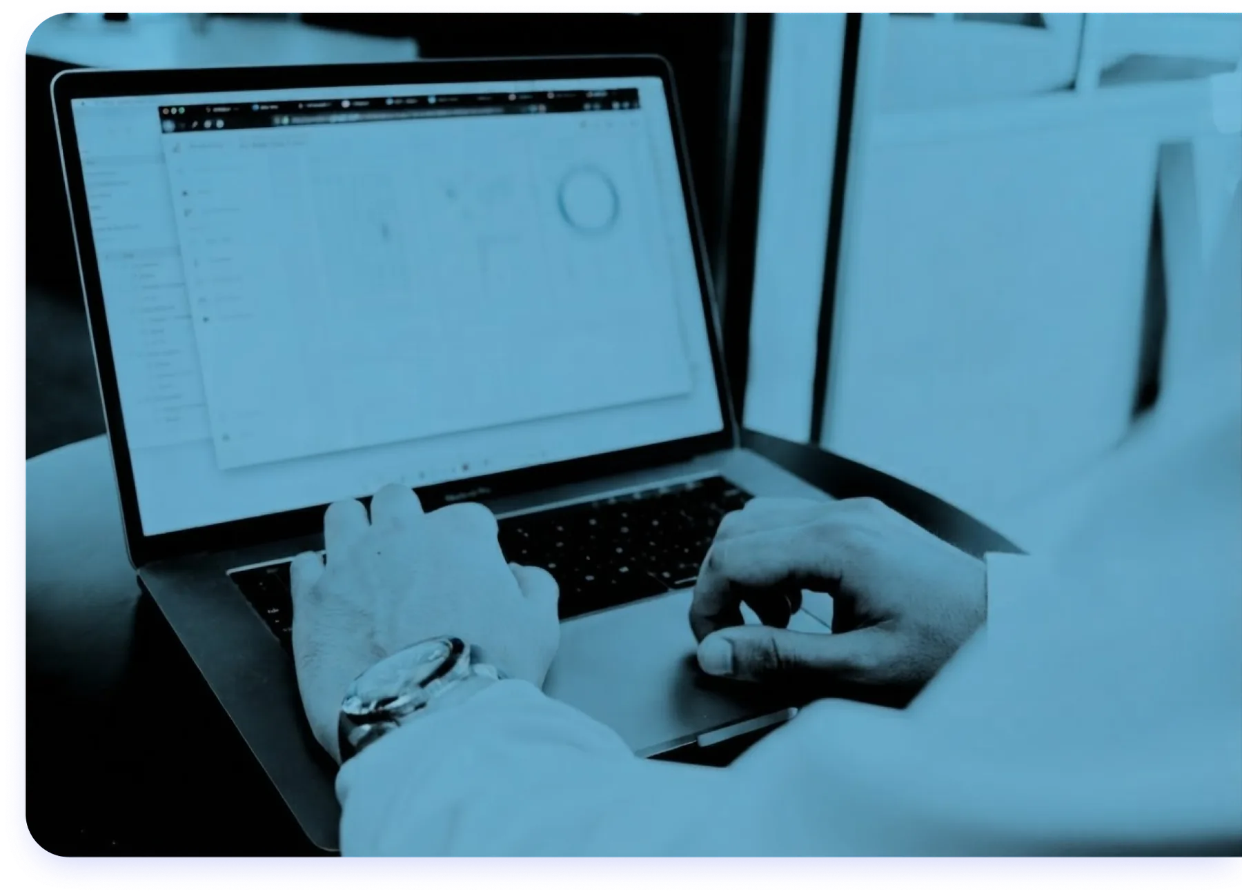 Hände arbeiten am Laptop mit Auswertungen auf dem Bildschirm